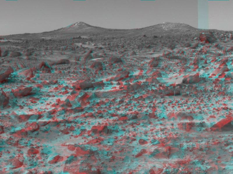The two hills in the distance in this stereo image from NASA's Mars Pathfinder have been dubbed the 'Twin Peaks.' 3D glasses are necessary to identify surface detail.