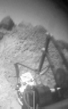This image of the rock 'Wedge' was taken from NASA's Sojourner rover's rear color camera on Sol 37. The segmented rod visible in the middle of the frame is the deployment arm for the Alpha Proton X-Ray Spectrometer (APXS).