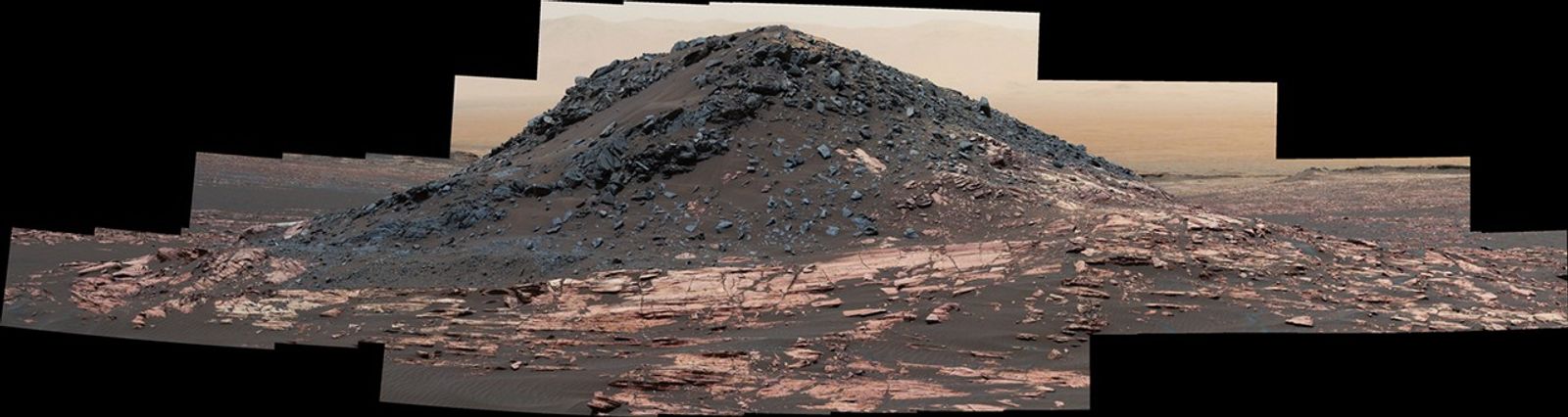 This view from the Curiosity Mars rover's Mastcam shows a dark mound, called "Ireson Hill," which rises about 16 feet above redder layered outcrop material on lower Mount Sharp, Mars, near a location where Curiosity examined a linear sand dune in February 2017.