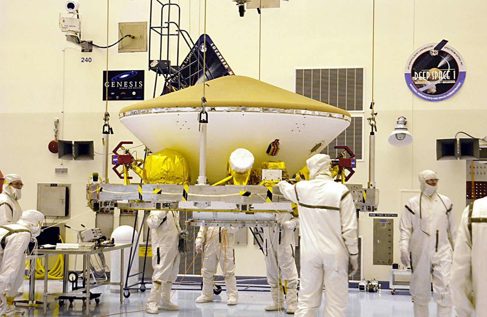 Suspended by an overhead crane in the Payload Hazardous Servicing Facility, the Mars Exploration Rover (MER) aeroshell is guided by workers as it moves to a rotation stand.