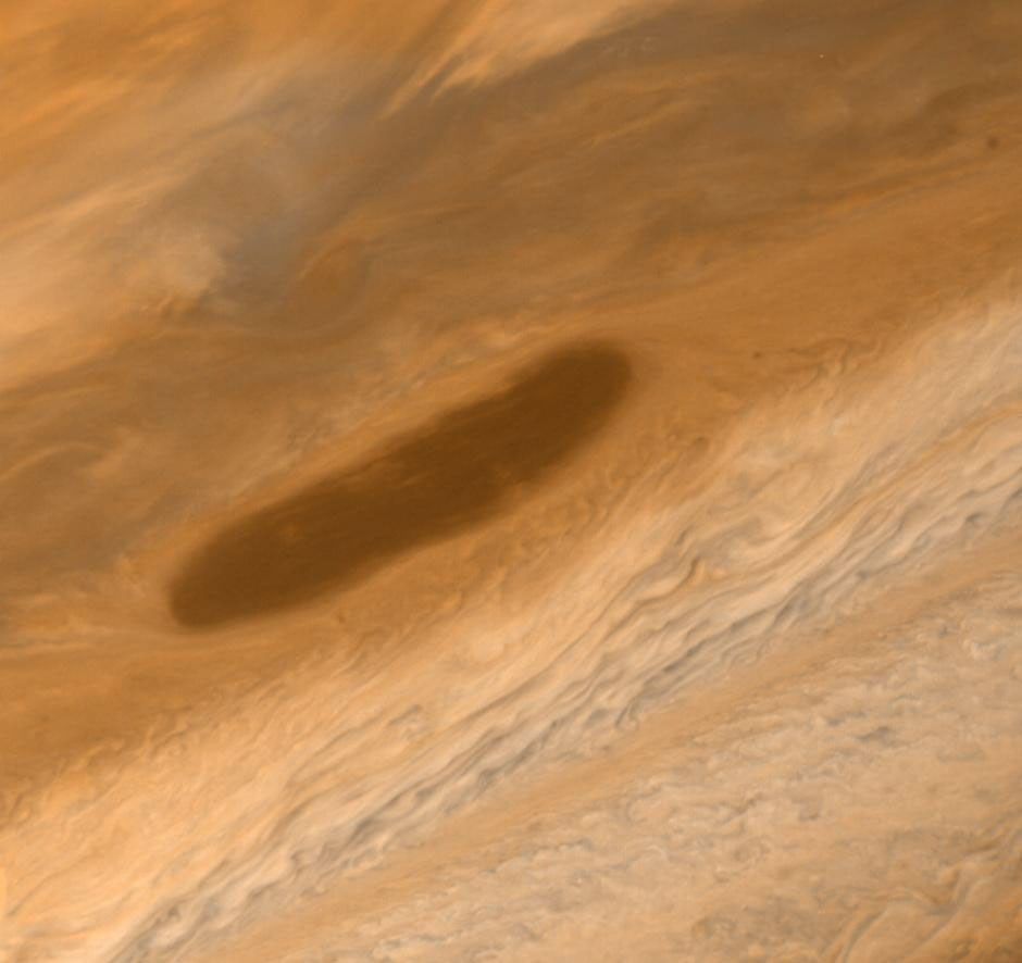 This large brown oval, photographed on Mar. 2, 1979 by NASA's Voyager 1. Features of this sort are not rare on Jupiter and have an average lifetime of one to two years. Above the feature is the pale orange North Temperate Belt.