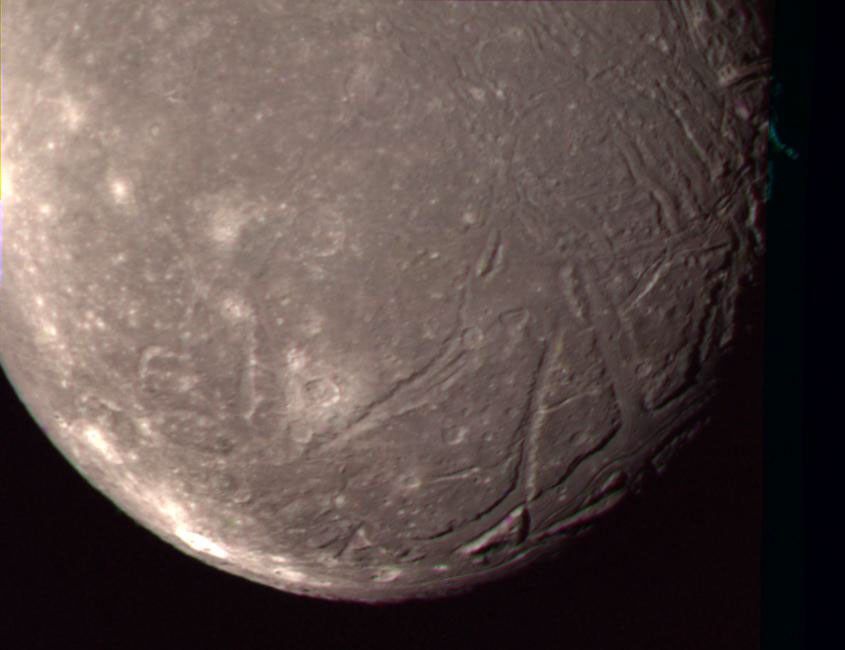 On Jan. 24, 1986, NASA's Voyager 2 obtained this color picture of the Uranian moon, Ariel. Most of the visible surface consists of relatively intensely cratered terrain transected by fault scarps and fault-bounded valleys (graben).
