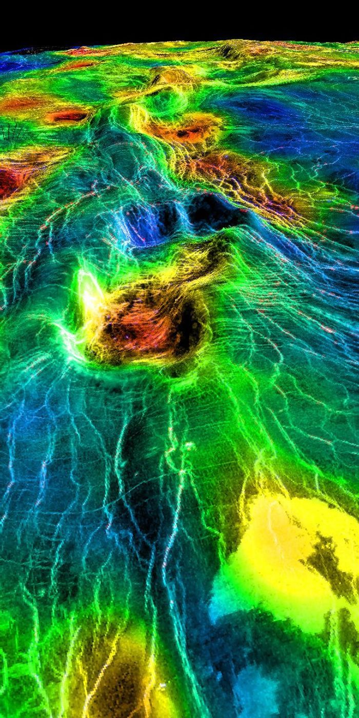 This perspective view of Venus, generated by computer from NASA's Magellan data and color-coded with emissivity, shows part of the lowland plains in Sedna Planitia. Circular depressions with associated fracture patterns, called 'coronae.'