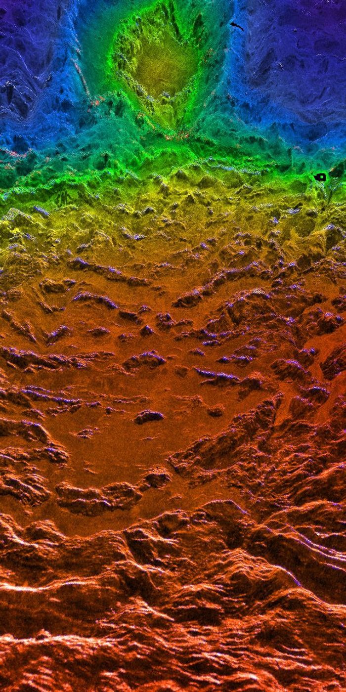 This perspective view of Venus, generated by computer from NASA's Magellan data and color-coded with emissivity, is a look westward across the Fortuna Tessera toward the slopes of Maxwell Montes.