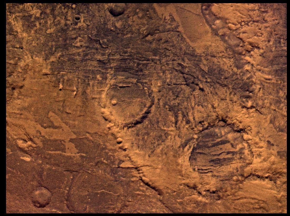 NASA's Viking Orbiter 2 shows Syria Planum-centered volcanism and tectonism produced fractures, narrow to broad grabens, large scarps, and broad fold and thrust ridges that deformed a basement complex.