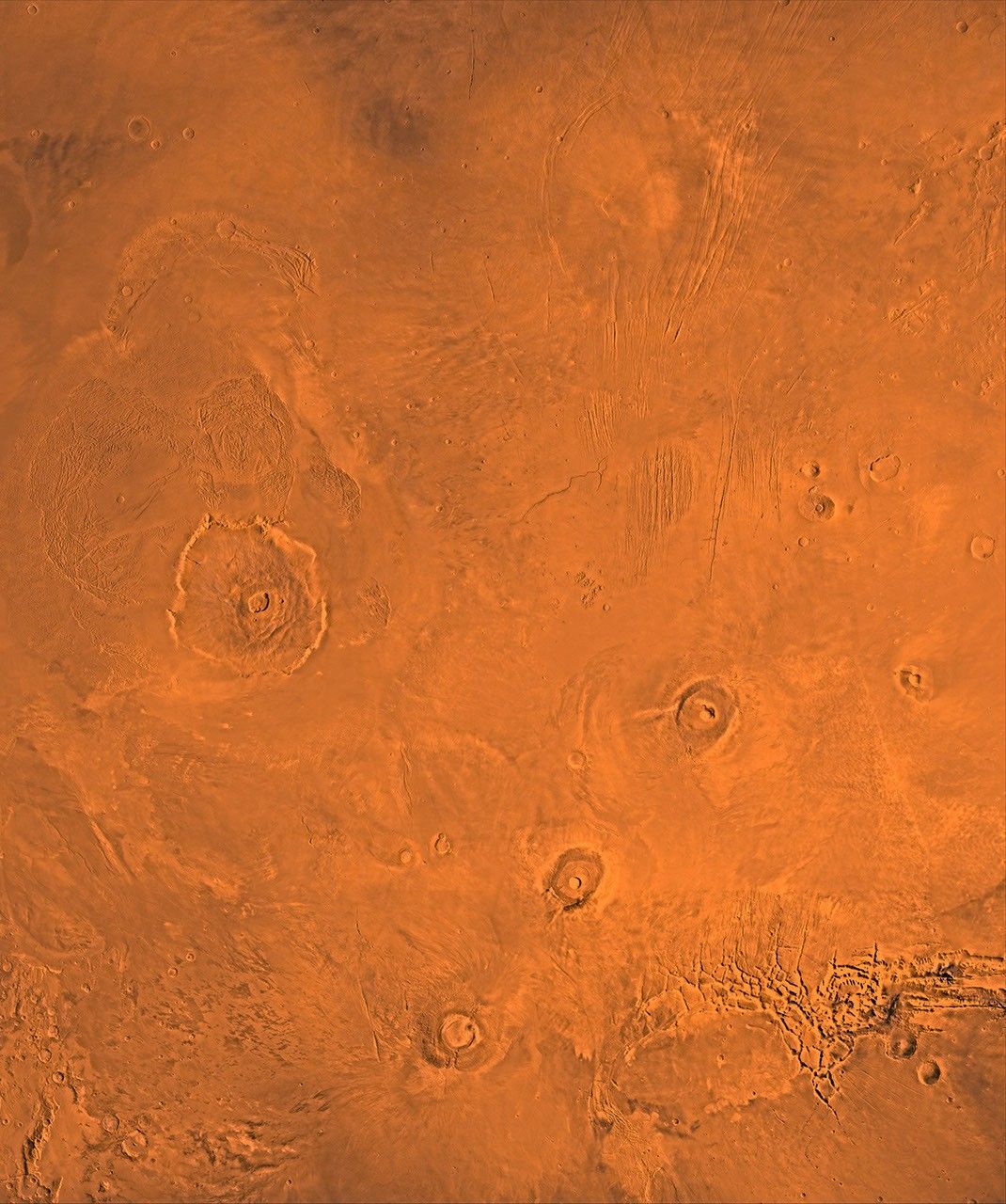 The Tharsis region of Mars; north toward top. This scene shows the Tharsis bulge, a huge ridge covered by the 3 large aligned Tharsis Montes shield volcanoes (from lower l to r): Arsia, Pavonis, and Ascraeus Mons as seen by NASA's Viking spacecraft.