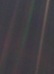 A dark, nearly black background with faint streaks of sunlight forming diagonal beams. In one of these beams, near the right side of the image, a minuscule, barely visible pale blue dot — Earth — stands out, appearing fragile and isolated against the vast emptiness of space. Taken on Feb. 14, 1990, by NASA's Voyager 1 spacecraft from 3.7 billion miles (6 billion kilometers) away, this iconic photograph underscores the profound vastness of the cosmos and Earth's tiny presence within it.