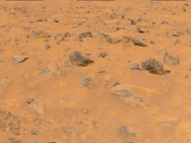 An area of rocky terrain and varied hues of soil is visible in the lower portion of this image, taken by NASA's Imager for Mars Pathfinder (IMP) on July 8, 1997. The lighter areas of soil may be partially composed of salts.