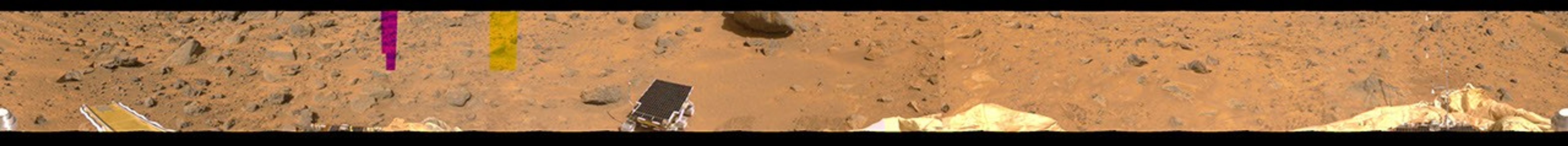 This image represents the first two tiers of a 360-degree color panorama, taken by NASA's Imager for Mars Pathfinder (IMP) on July 9, 1997. At left, the forward ramp is visible near the larger rocks.