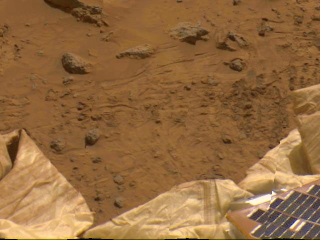 Portions of the lander's deflated airbags and a petal are at the lower area of this view, imaged by NASA's Imager for Mars Pathfinder (IMP) as part of a 360-degree color panorama, taken over sols 8, 9 and 10. Sol 1 began on July 4, 1997.