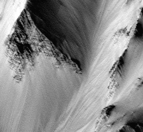 Banded outcrops in walls of Tithonium Chasma/Ius Chasma section of Vallis Marineris. This 4.6 x 4.3 km image (frame 1303) is centered near 6.6 degrees south, 90.4 degrees west, taken by NASA's Mars Global Surveyor Orbiter.