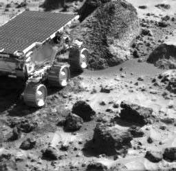 This image, taken by NASA's Imager for Mars Pathfinder (IMP) at the end of Sol 35, shows the Sojourner rover heading toward a rock called 'Wedge.' Sol 1 began on July 4, 1997.