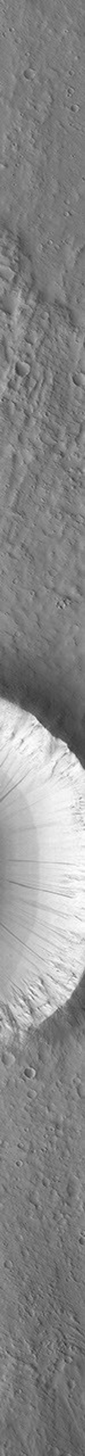 This image of a moderately small impact crater on Mars was taken by the Mars Global Surveyor Orbiter Camera (MOC) on October 17, 1997. Long, linear features of different brightness values are seen on the steep slopes inside and outside the crater.