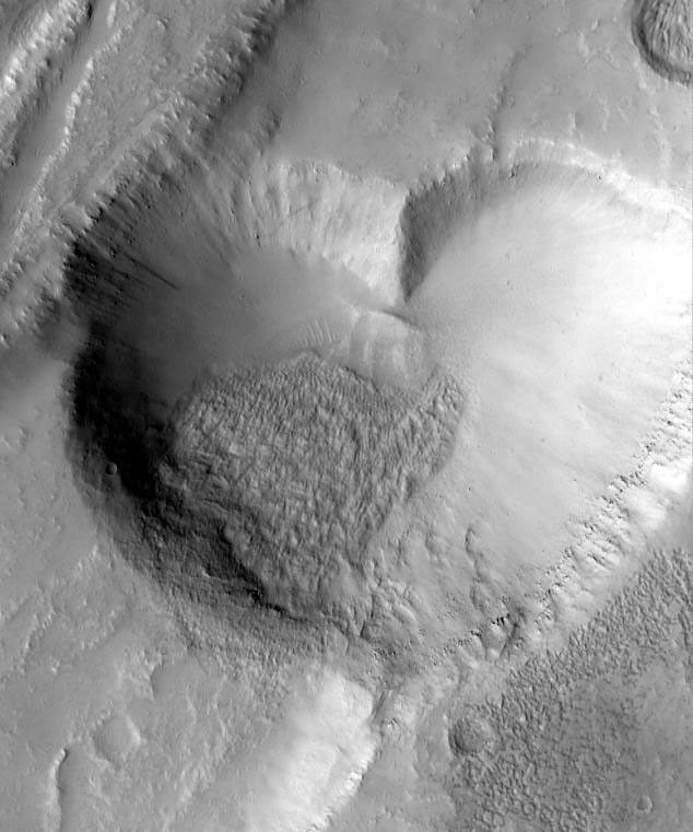 NASA's Mars Global Surveyor captured this 'valentine' from Mars in 1999. The graben, pit, and lava flow are located on the east flank of the Alba Patera volcano in northern Tharsis.