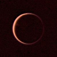 NASA's Voyager 2 obtained this wide-angle image of the night side of Titan on Aug. 25, 1979. This is a view of Titan's extended atmosphere. the bright orangish ring being caused by the atmosphere's scattering of the incident sunlight.