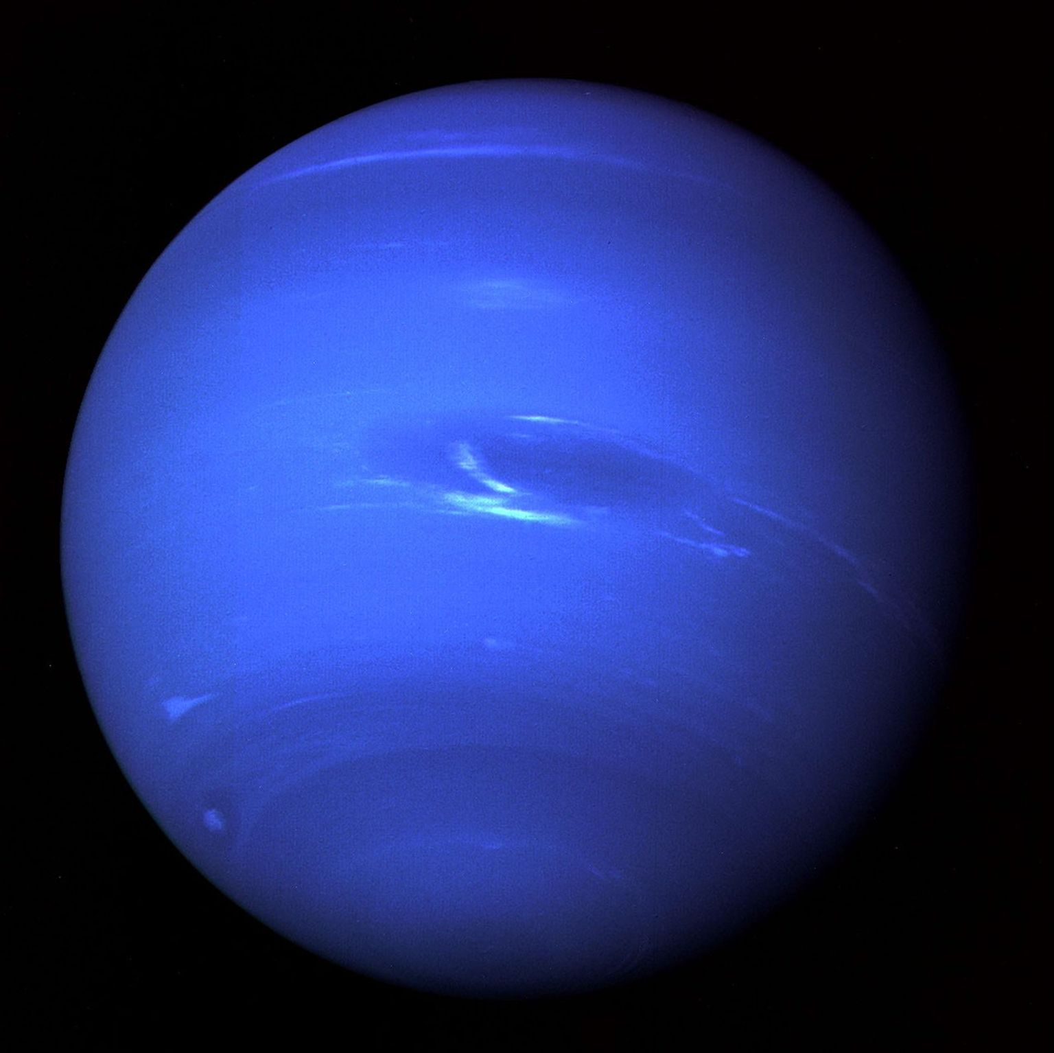 The image of Neptune shows the Great Dark Spot and its companion bright smudge; on the west limb the fast moving bright feature called Scooter and the little dark spot are visible in this image obtaind by NASA's Voyager 2.