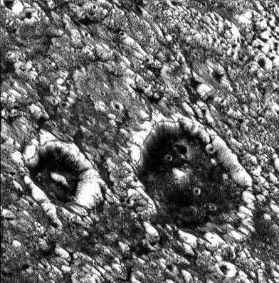 This image from NASA's Galileo spacecraft shows two impact craters that are superimposed on Memphis Facula, a large bright circular feature in the otherwise generally dark terrain in Galileo Regio on Jupiter's moon, Ganymede.