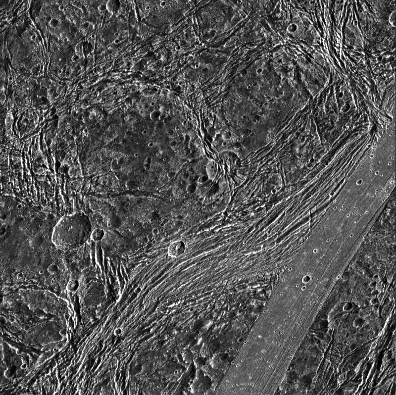 View of Nicholson Regio on Jupiter's moon, Ganymede, showing heavily fractured dark terrain and a lane of smooth bright terrain. North is to the top of this image from NASA's Galileo spacecraft.