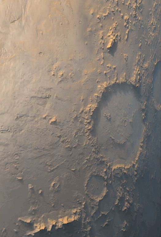 This image was captured by NASA's Mars Global Surveyor during March 1999 showing Galle Crater smiling back at the camera from its location on the east side of Argyre Planitia on Mars. The bluish-white tone is caused by wintertime frost.