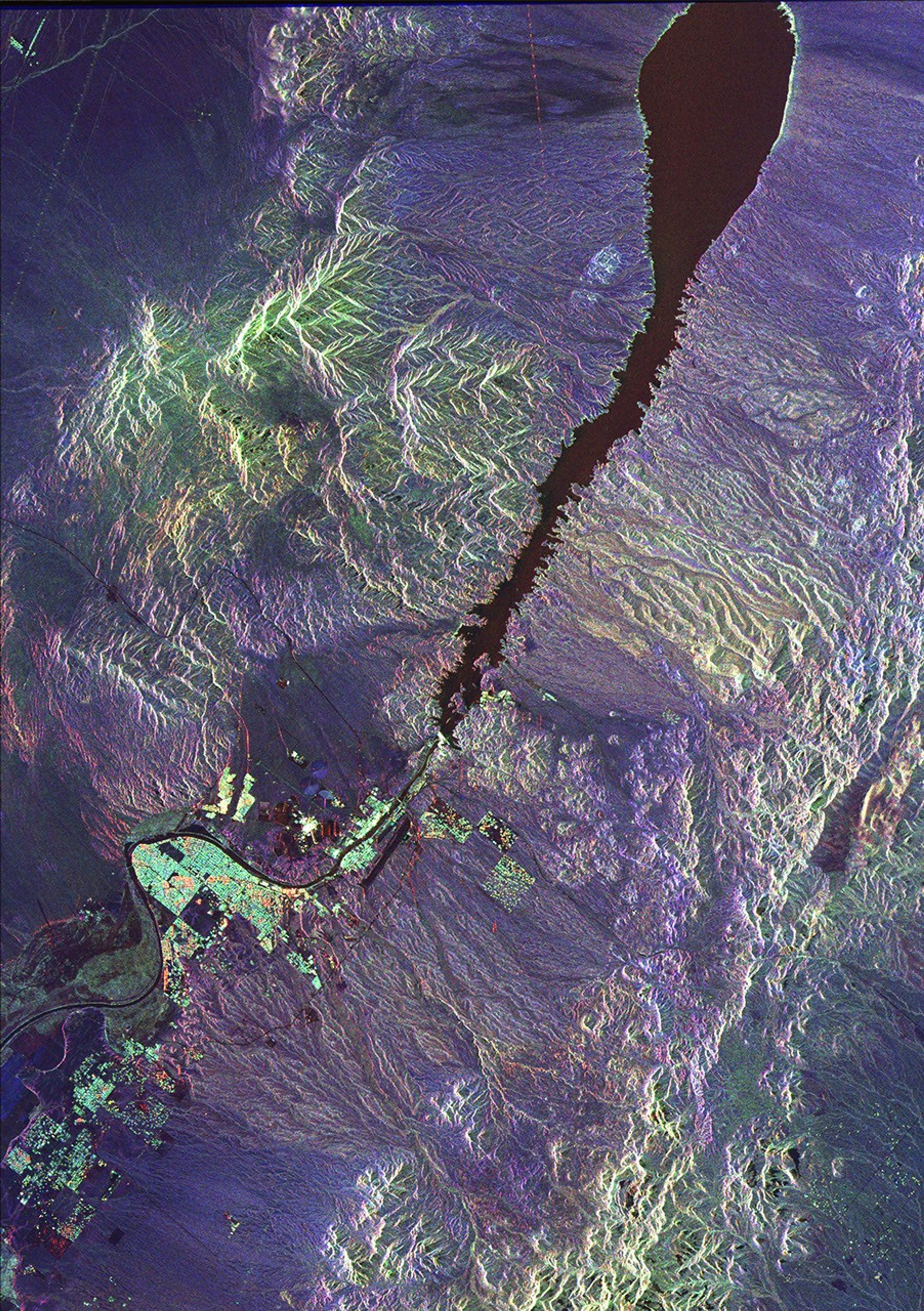 This space radar image from NASA's Spaceborne Imaging Radar-C/X-band Synthetic Aperture shows urban development along the lower Colorado River at the Nevada/Arizona state line. Lake Mojave is the dark feature that occupies the river valley.