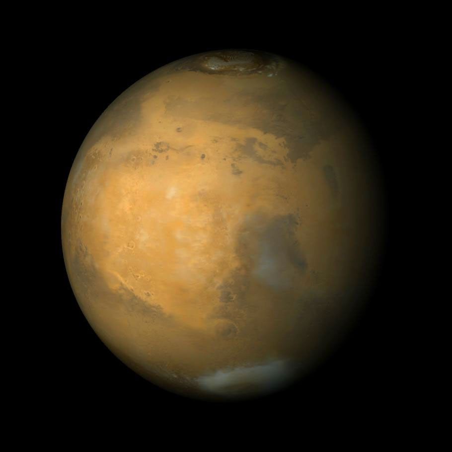 NASA's Mars Global Surveyor shows a large, circular bright region called Arabia Terra. Syrtis Major is the dark region toward the lower right. The north polar cap is visible at the top, and the bright feature lower right is the Hellas Basin.