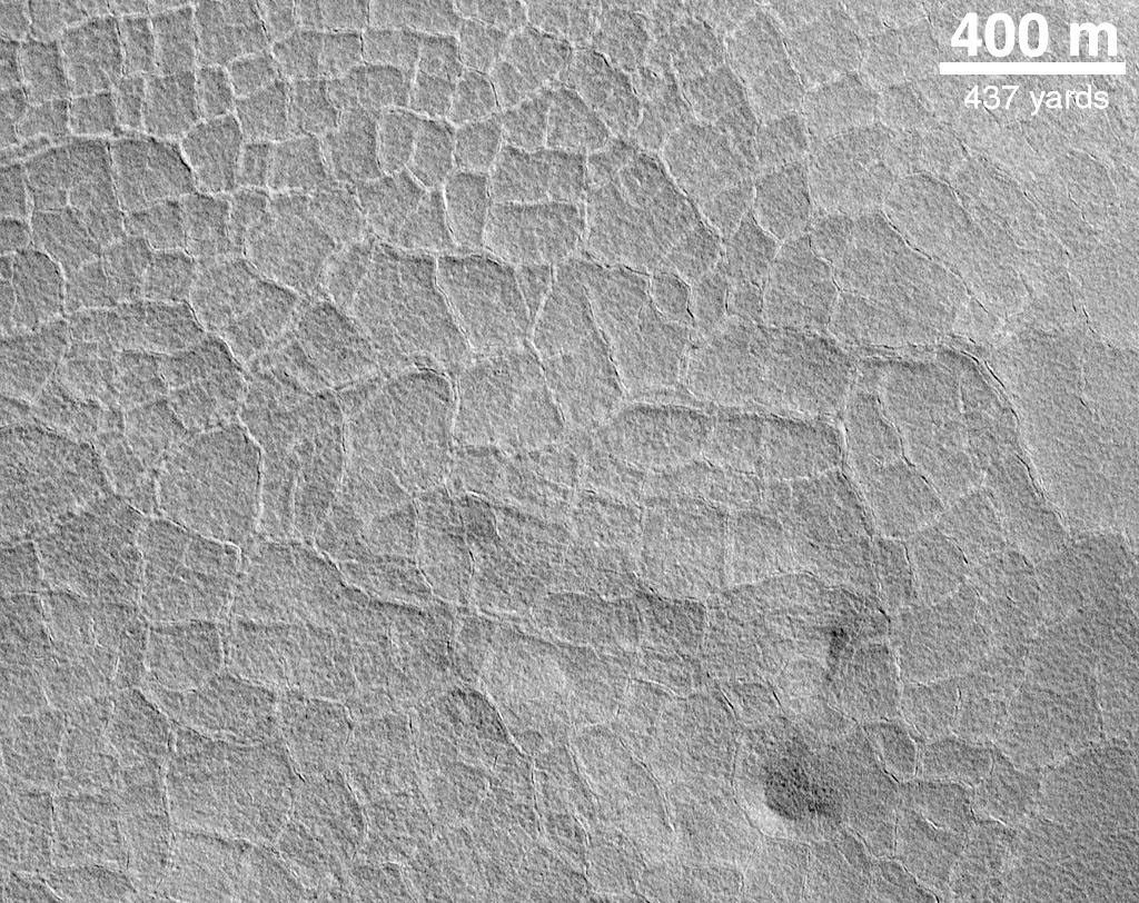 NASA's Mars Global Surveyor shows the floor of an old impact crater on the northern plains of Mars. Each 'tile' is somewhat larger than a football field.