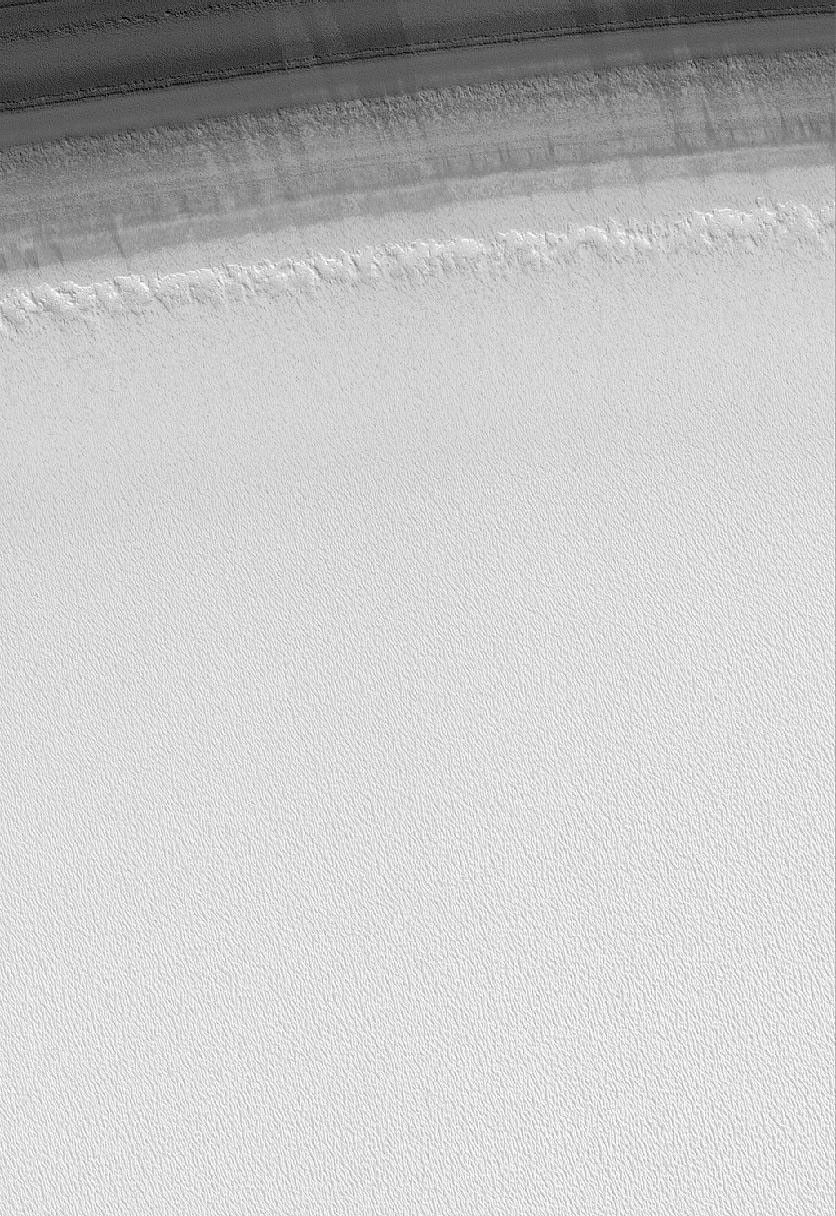 This image from NASA's Mars Global Surveyor shows a transition from one of the many layered troughs in the north polar region of Mars to the relatively homogeneous-looking upper surface of the polar cap.