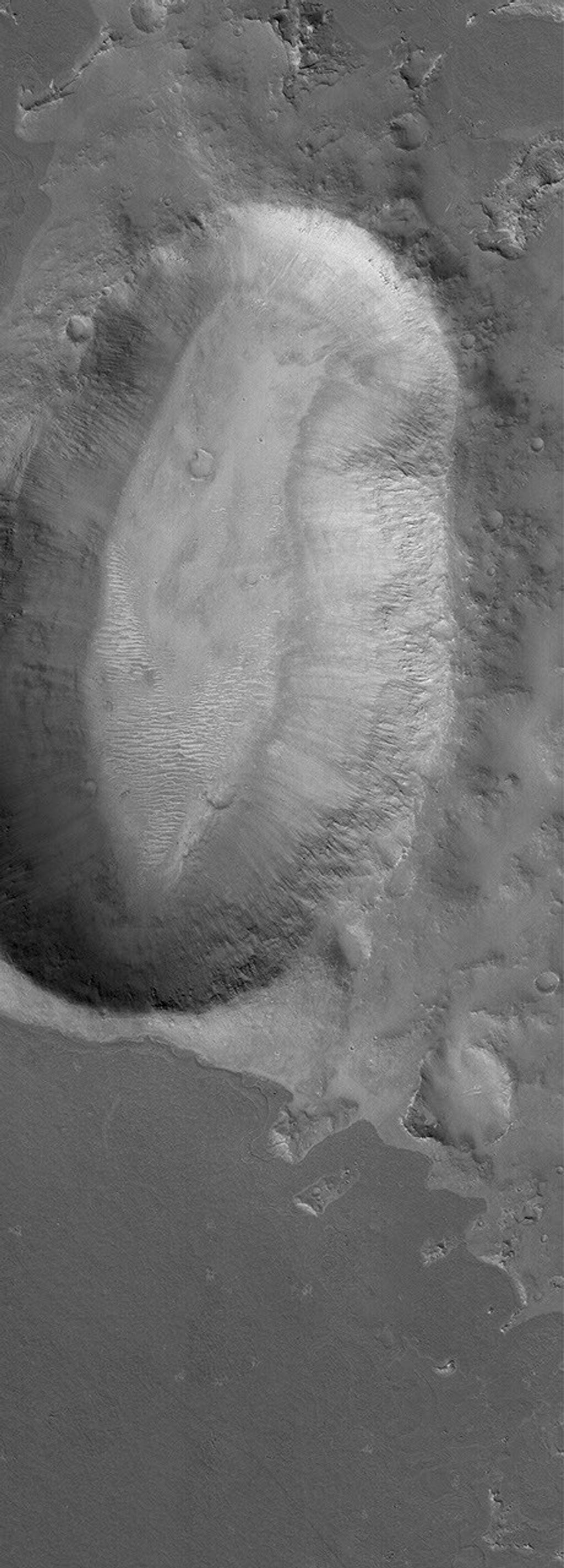 This image from NASA's Mars Global Surveyor shows an unusally-shaped (not circular) impact crater in the Elysium region of Mars. A dark-toned lava flow surface is seen in the southern (lower) portion of the image.