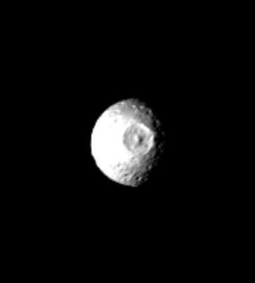 This NASA Voyager 1 picture of Mimas shows a large impact structure at 110 W Long., located on that face of the moon which leads Mimas in its orbit. The feature, about 130 kilometers in diameter, is more than one-quarter the diameter of the entire moon.
