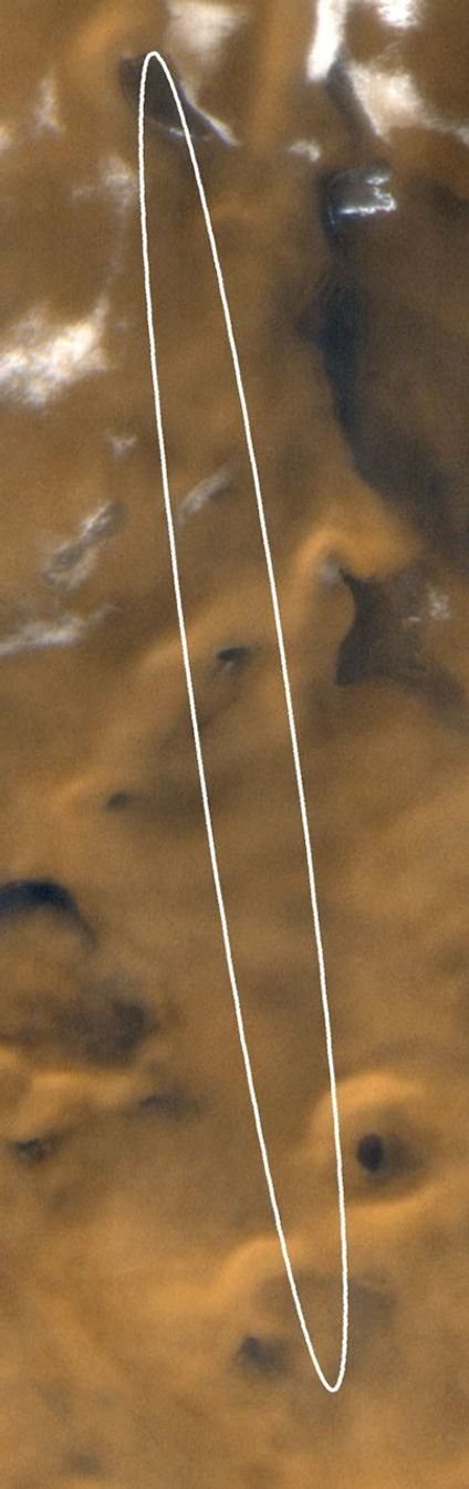 NASA's Mars Global Surveyor shows late spring in this portion of the martian south polar region. Dark patches within the ellipse are sand and small fields of windblown sand dunes. The bright patches toward the top of the image are frost.
