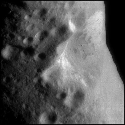 This image from NASA's NEAR Shoemaker shows an oblique view of Eros' large central crater. Brightness or albedo patterns on the walls of this crater are evident as are boulders inside this crater and the smaller nearby craters.
