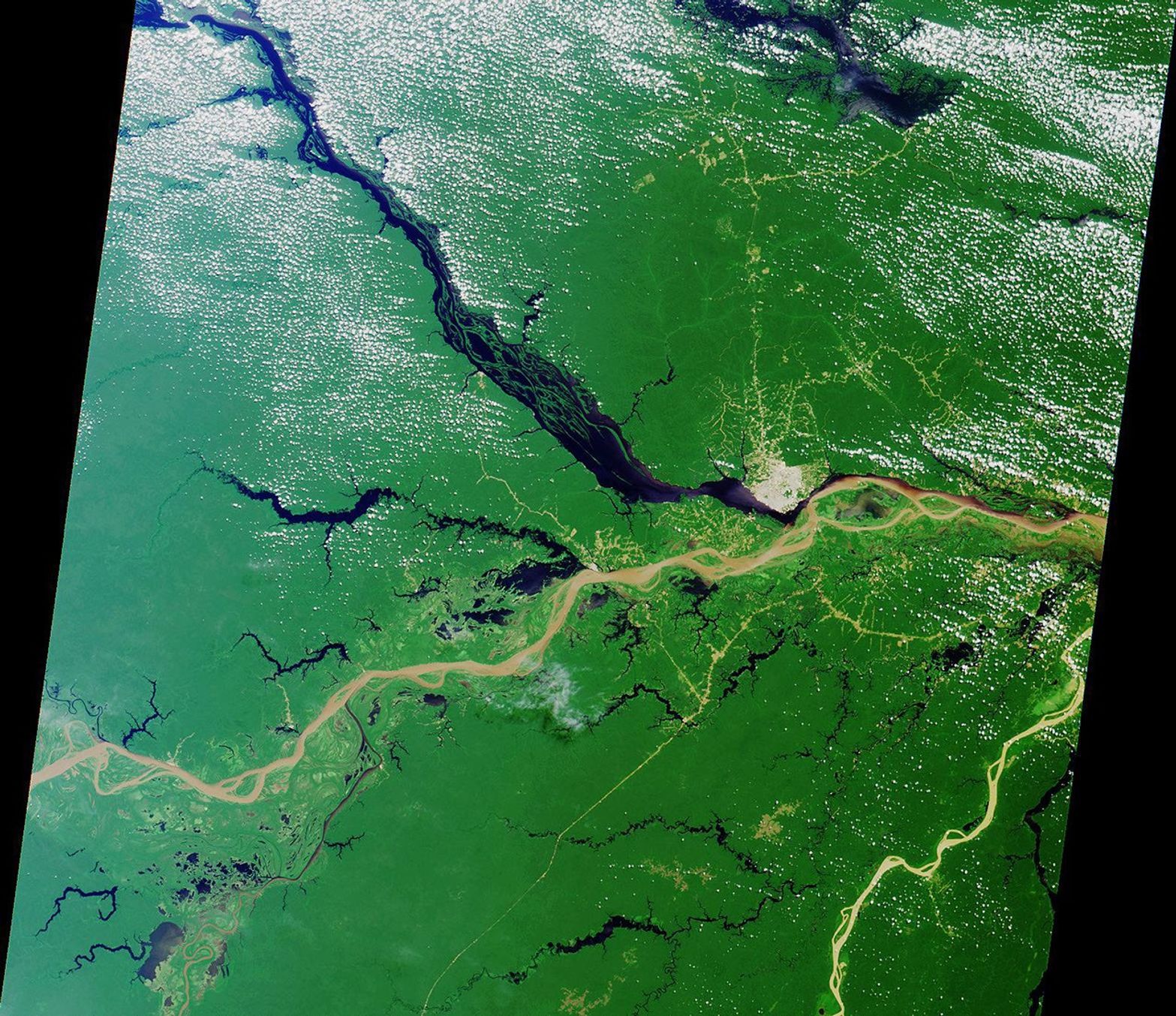 Close to the city of Manaus, Brazil the Rio Solimoes and the Rio Negro converge to form the Amazon River. This image from NASA's Terra satellite was acquired on July 23, 2000 during Terra orbit 3178.