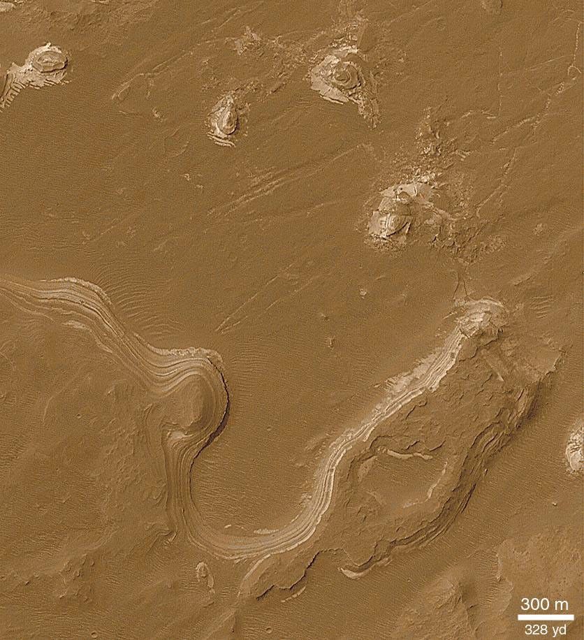 NASA's Mars Global Surveyor shows layered outcrops in craters and chasms in Gale Crater on Mars seen as stair-stepped series of cliffs and benches composed of similar materials with similar thicknesses.