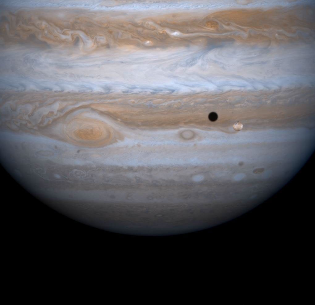 Jupiter's four largest satellites, including Io, the golden ornament in front of Jupiter in this image from NASA's Cassini spacecraft.