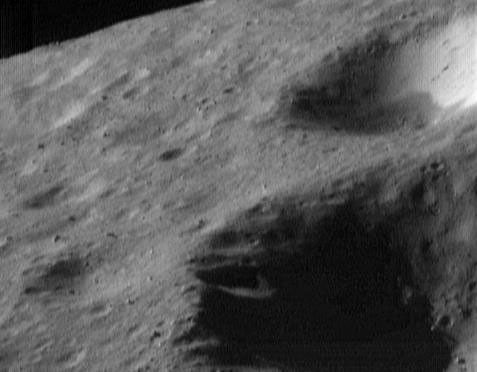 This image of asteroid Eros, taken by NASA's NEAR Shoemaker on May 2, 2000, shows a view toward Eros' horizon with variations in the brightness of material on the walls of the craters; and a scattering of boulders.