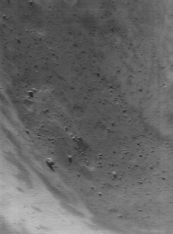 This image of asteroid Eros, taken by NASA's NEAR Shoemaker on June 6, 2000, shows a view from the edge of the large, 5.3-kilometer (3.3-mile) diameter crater, looking into its depths.