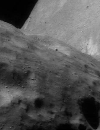 This image of asteroid Eros, taken by NASA's NEAR Shoemaker on June 20, 2000, shows a stunning aspect of the bent asteroid's peanut-like shape. The far side looms like an enormous wall beyond a near horizon.