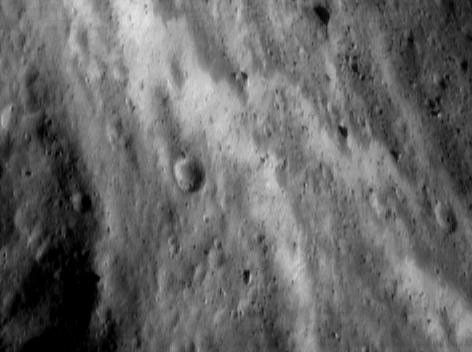 This image of asteroid Eros, taken by NASA's NEAR Shoemaker on June 19, 2000, shows the southwestern wall of the saddle containing bands of bright regolith.