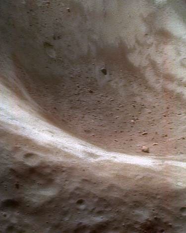This false-color image of asteroid Eros, taken by NASA's NEAR Shoemaker on June 14, 2000, shows redder hues as rock and regolith, altered chemically by exposure to solar wind and small impacts. Bluer hues are fresher, less-altered rock and regolith.