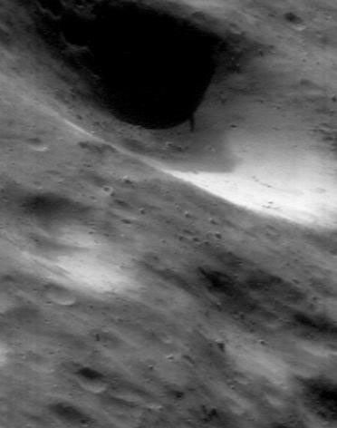 This image of asteroid Eros, taken by NASA's NEAR Shoemaker on July 23, 2000, shows that impact excavated a huge gouge, and caused some of the excavated material to form a thin cover on parts of Eros.