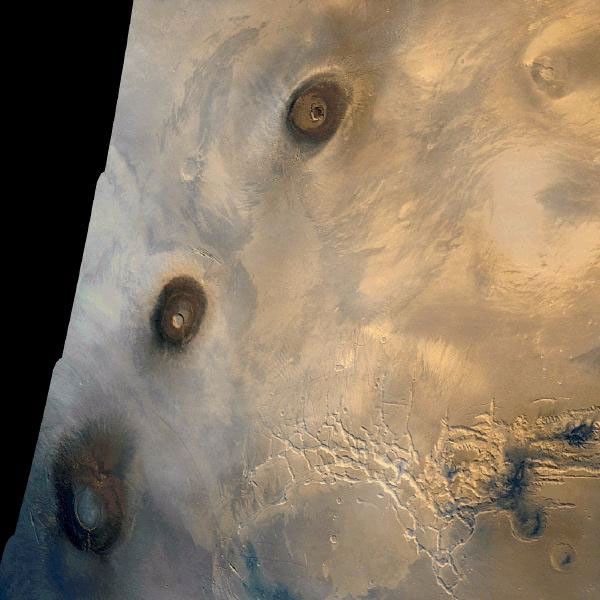 NASA's Viking 1 Orbiter color mosaic of the eastern Tharsis region on Mars. At left, from top to bottom, are the three 25 km high volcanic shields, Ascraeus Mons, Pavonis Mons, and Arsia Mons.