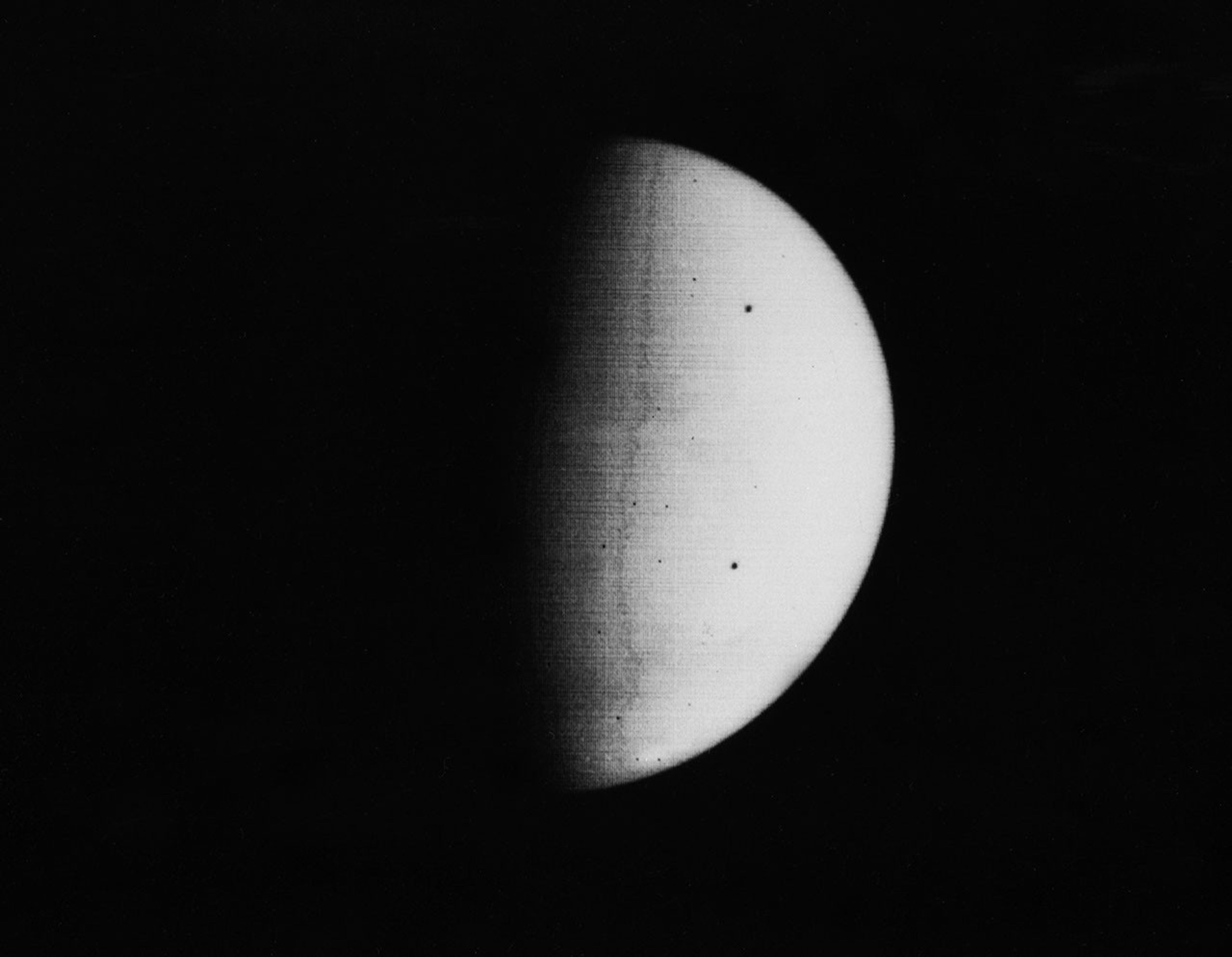 NASA's Mariner 9 took this picture of Mars on November 11, 1971, during its approach to the planet. The south polar cap (at the bottom of the planet disc) shines dimly through the apparent atmospheric haze, probably dust.