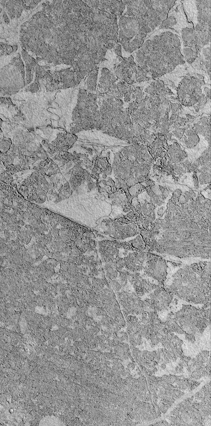 NASA's Mars Global Surveyor shows the broken, platy texture of flow surfaces in the Zephyria region of Mars. Small craters formed on these surfaces, and some of them have boulders in their ejecta.