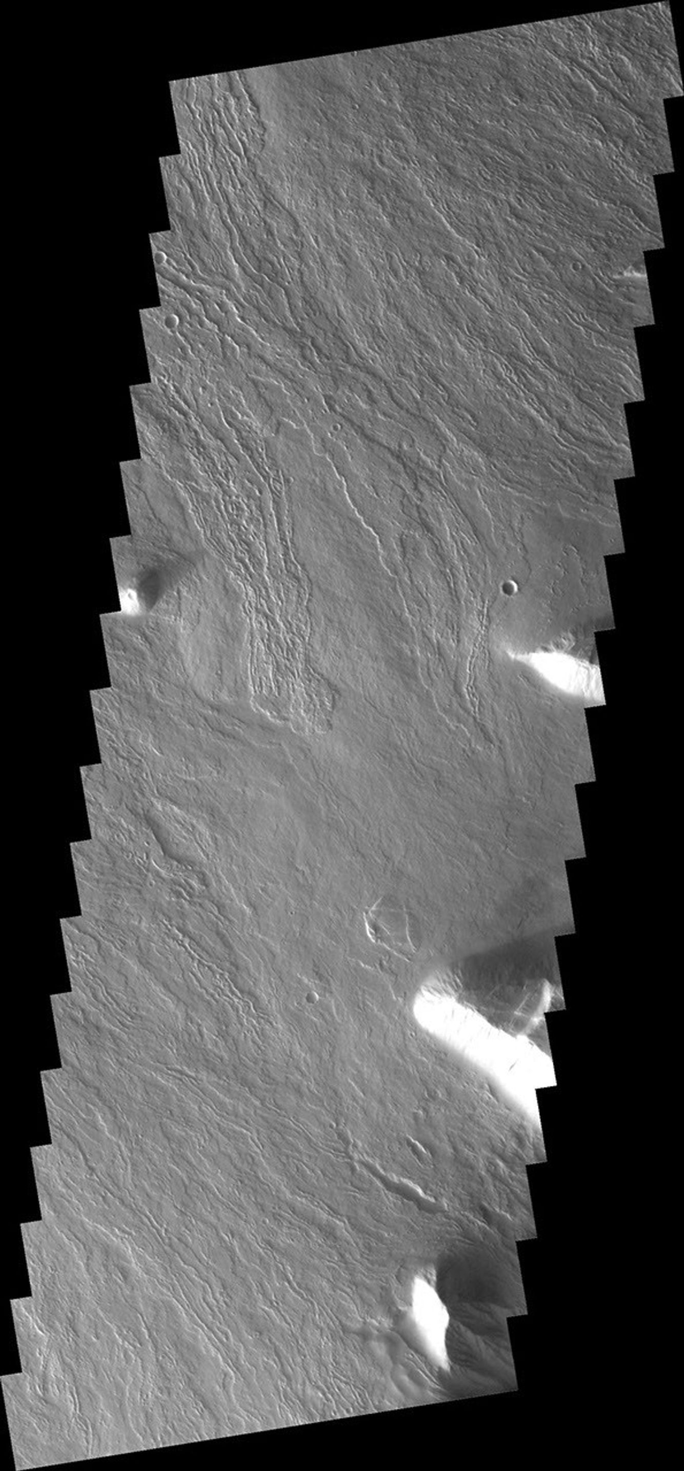 This image from NASA's 2001 Mars Odyssey spacecraft shows just a small part of the eastern flank of Olympus Mons on Mars. On the far left side of the image a small volcanic cone can be seen. The shadow helps to identify this feature.