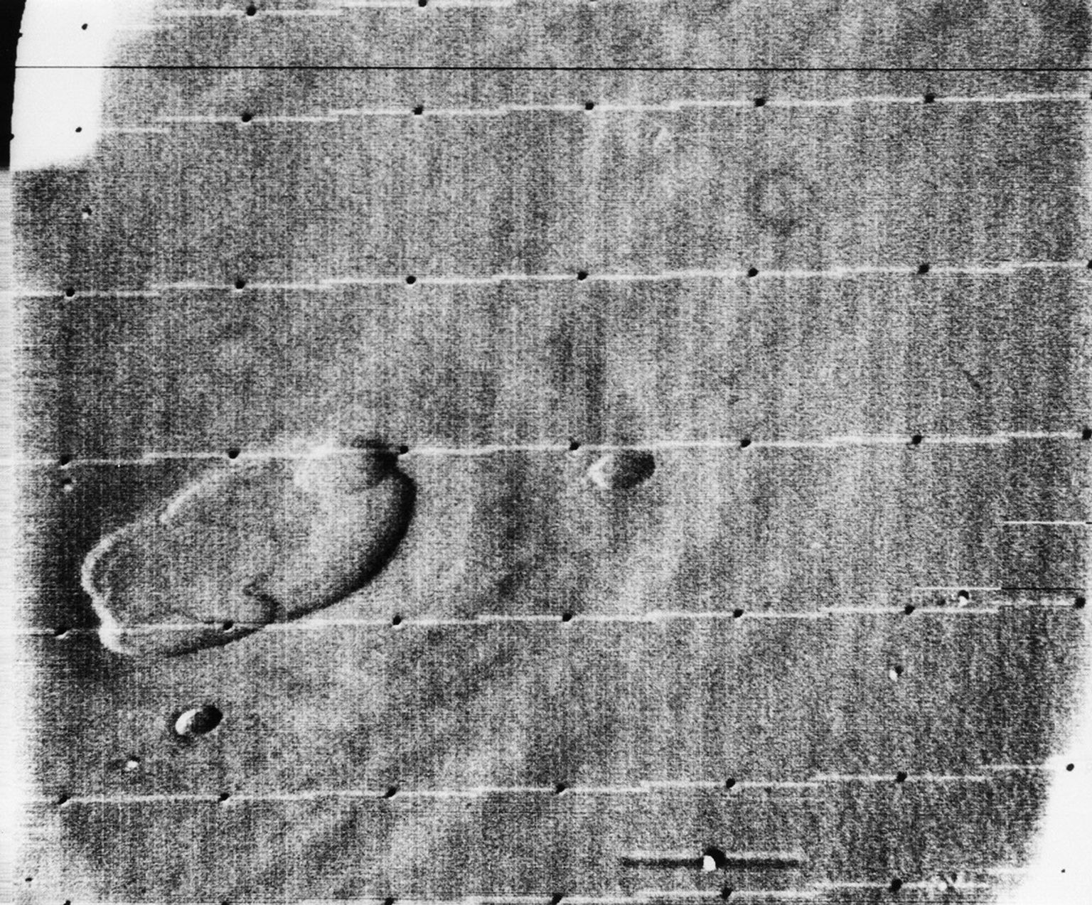 This is an oblique view of the crater complex near Ascraeus Lacus in the Tharsis region of Mars was taken by NASA's Mariner 9 in 1971. The spot consists of several intersecting shallow crater-like depressions.