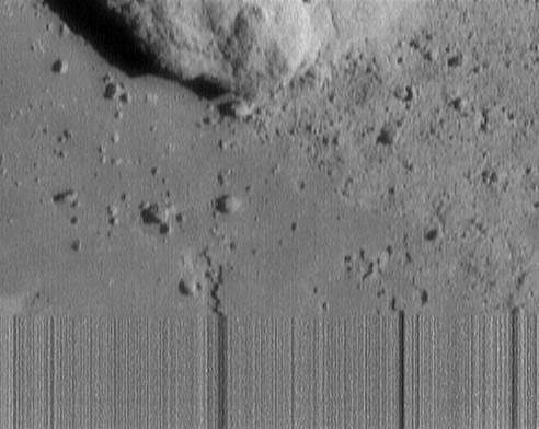 This image of asteroid 433 Eros, was the last received from NASA's NEAR Shoemaker. Streaky lines at the bottom indicate loss of signal as the spacecraft touched down on the asteroid during transmission of this image.