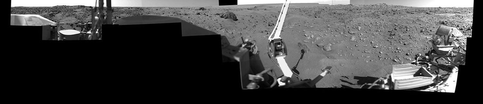 This image was taken by NASA's Viking Lander 1 at Chryse Planitia on Mars. The lander can be seen in the foreground looking toward the rugged martian terrain.