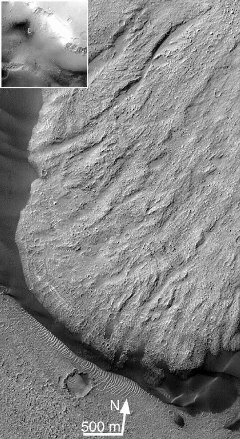 NASA's Mars Global Surveyor shows shear striations, dark dunes banked up against the toe of the slide and over-riding light-toned ripples and boulders on the toe of Ganges Chasma on Mars.