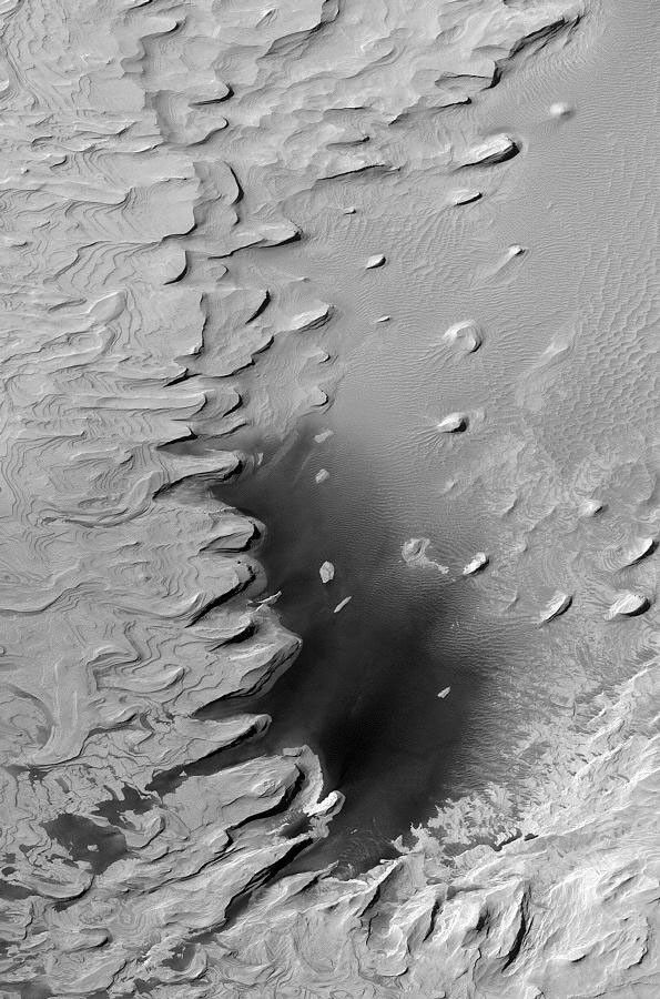 NASA's Mars Global Surveyor shows layered rock outcrops reaching deep down into the martian crust in the walls of the Valles Marineris.