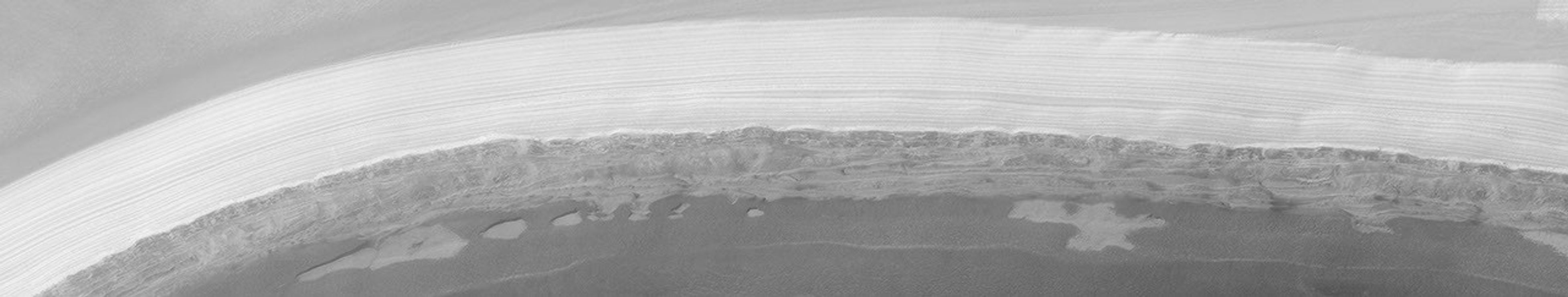 NASA's Mars Global Surveyor shows Mars' polar cap with two types of layers, a stack of light-toned, nearly uniformly-bedded layers at the top, and a stack of darker-toned beds that form shelves and benches at the bottom.
